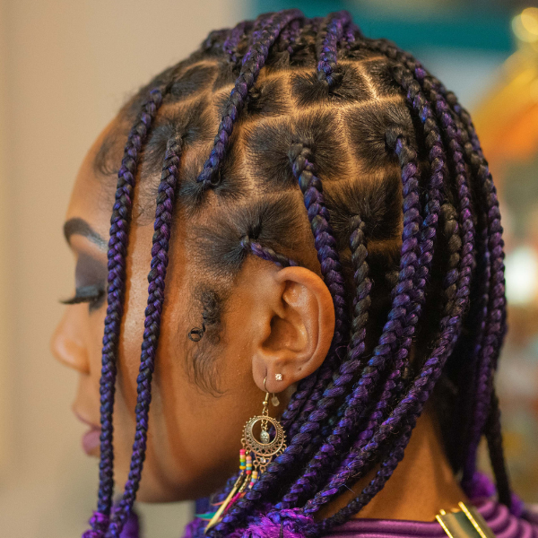 Close-up of vibrant purple and black braided hairstyle, showcasing clean parts and precise braiding technique. Ideal for protective styles using O Gel for hold and shine by Evolving Textures.